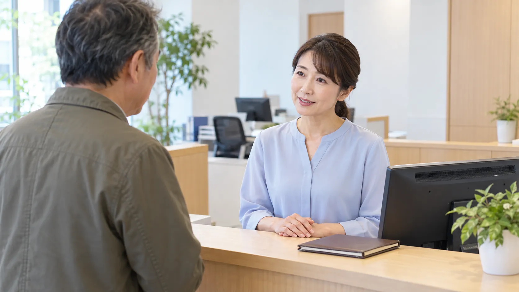 受付カウンターでお客様の問い合わせに対応するスタッフ
